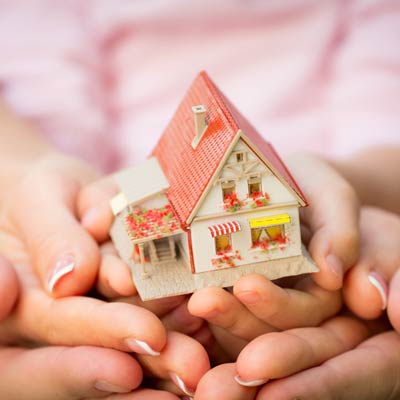 family hands holding model home