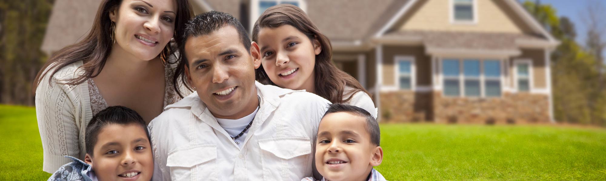 happy family smiling in front of home